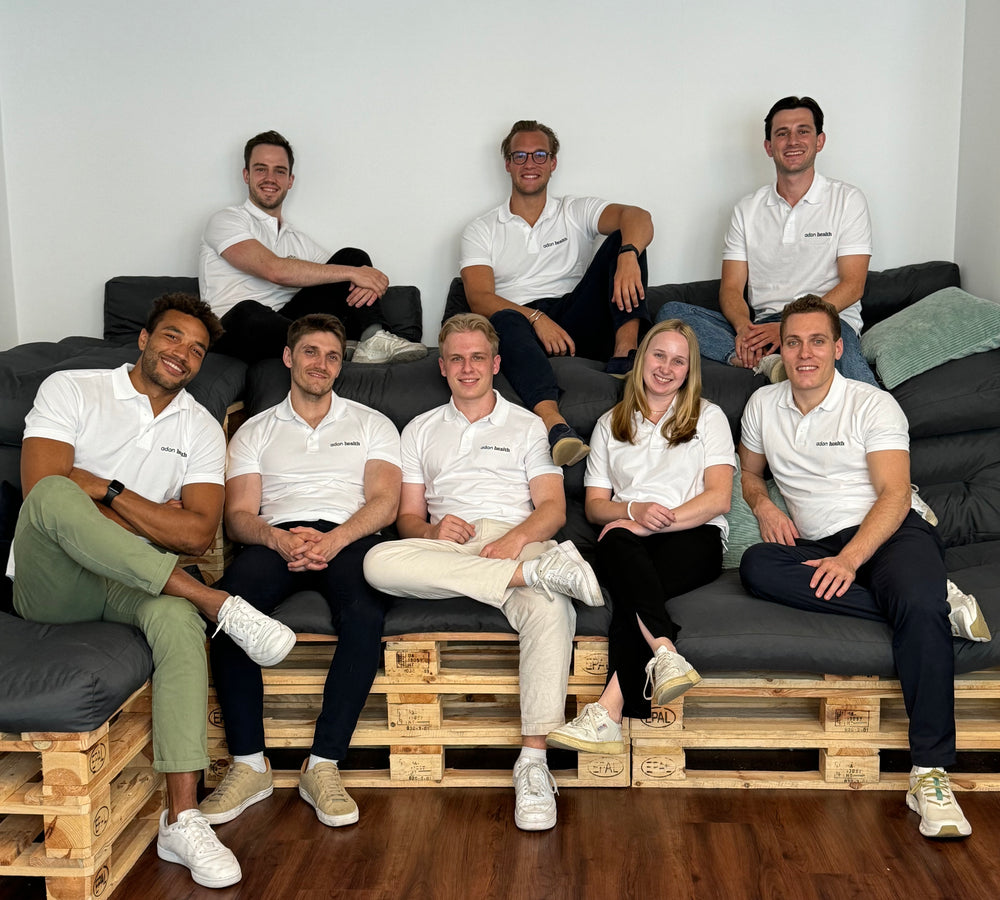 Team von Adon Health sitzt auf Couch und lacht in die Kamera
