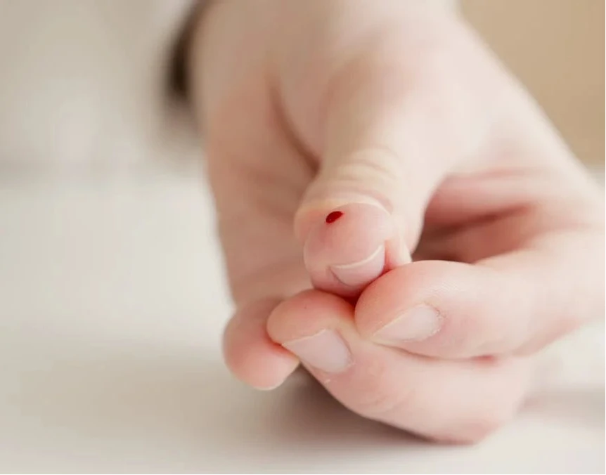 Finger mit Bluttropfen